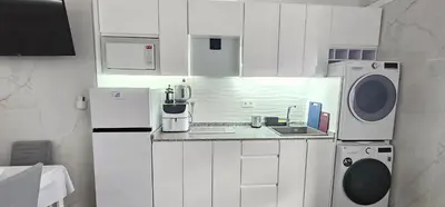 a kitchen with white cabinets and a washer and dryer at A45 ViviendaTurísticaValencia Mundo in Valencia