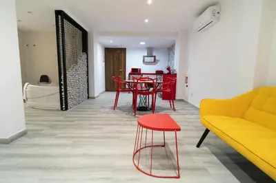 a living room with a yellow couch and a red stool at ROMANTICA in Anna