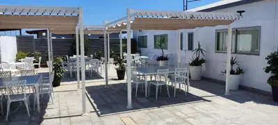 a patio with tables and chairs under a pergola at Hotel Ruta Romana in Sagunto