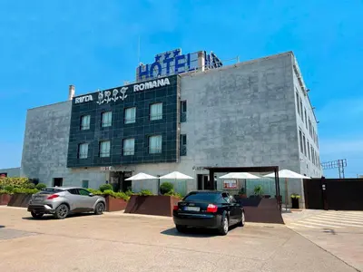 a building with two cars parked in front of it at Hotel Ruta Romana in Sagunto