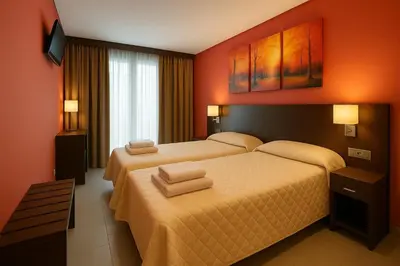 two beds in a hotel room with orange walls at Hotel Ruta Romana in Sagunto