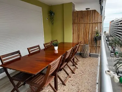 a wooden table and chairs on a balcony at Don Quijote CABANAL in Cullera