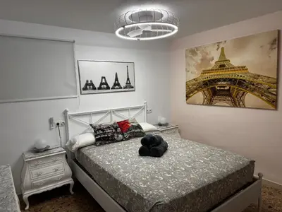 a bedroom with a bed and a picture of the eiffel tower at Don Quijote CABANAL in Cullera
