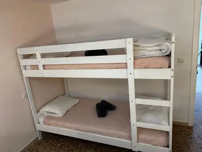 a white bunk bed with shoes on the bottom bunk at Don Quijote CABANAL in Cullera