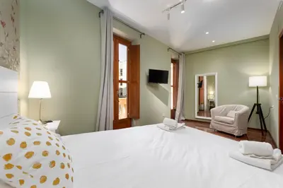 a dining room with a table and a green wall at Adarve Flats in Valencia