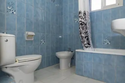 a blue tiled bathroom with a toilet and a bath tub at El Raco, A-7-13 in Cullera