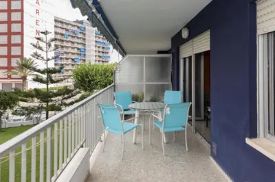 a balcony with a table and blue chairs at Nereidas, A-2, 1-2 in Cullera