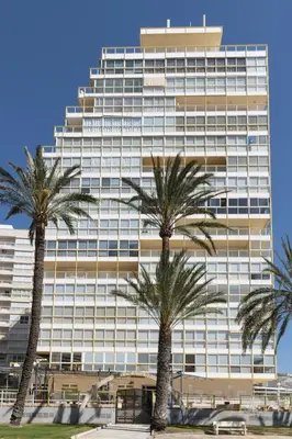 a tall building with palm trees in front of it at Florazar-3, 14-E in Cullera