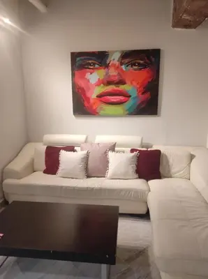 a living room with a couch with a painting on the wall at APARTAMENTOS En Plom in Valencia