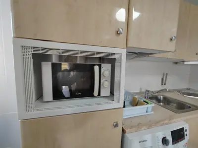 a microwave oven sitting on top of a kitchen counter at Tout près de la plage in Puerto de Sagunto