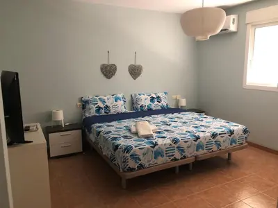 a bedroom with a bed with blue sheets and a television at CASA MANUELA in Chella