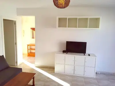 a living room with a tv on a white cabinet at Ático a 100 metros de la playa in Cullera
