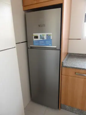a refrigerator in the corner of a kitchen at Ático a 100 metros de la playa in Cullera
