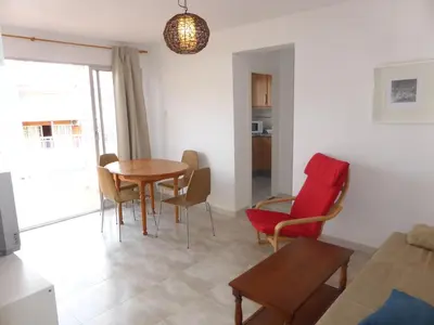 a living room with a table and chairs at Ático a 100 metros de la playa in Cullera