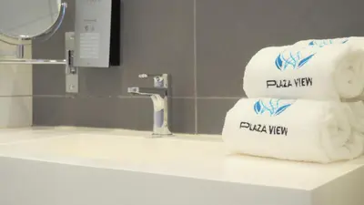 a stack of folded towels sitting on a bathroom sink at PLAZA VIEW in Valencia