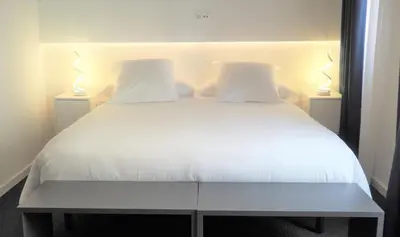 a bedroom with a white bed with two lamps at PLAZA VIEW in Valencia