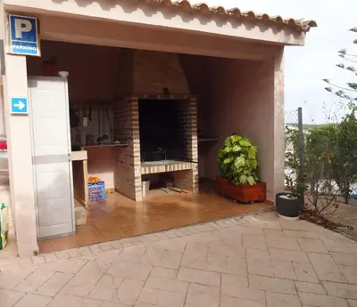 a patio with a fireplace in a house at LAS PALOMAS, appartement 2 chambres avec piscine in Turís