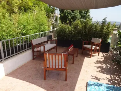 a group of chairs and tables on a patio at LAS PALOMAS, appartement 2 chambres avec piscine in Turís