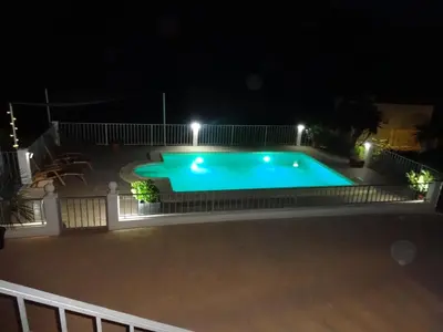 a swimming pool at night with lights at LAS PALOMAS, appartement 2 chambres avec piscine in Turís