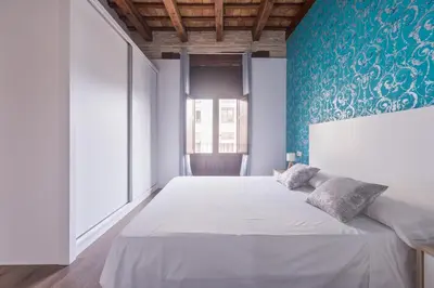 a bedroom with a large bed with a blue wall at San Miguel, Luxury apartments. in Valencia