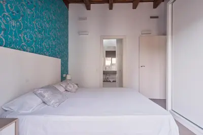 a bedroom with a white bed and a green wall at San Miguel, Luxury apartments. in Valencia