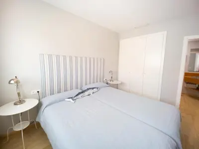 a white bedroom with a bed and a table at Valencia Beach Apartments 2 in Valencia