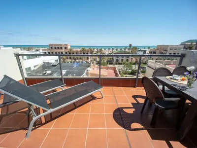 a balcony with a table and chairs and a view of the ocean at Valencia Beach Apartments 2 in Valencia