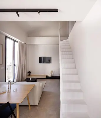 a white staircase in a living room with a table at YOURS boutique stay in Valencia