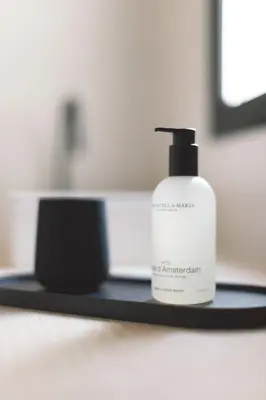a white bottle of soap sitting on a black shelf at YOURS boutique stay in Valencia