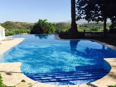 a large pool with blue water in a yard at Villa Charly Casa señorial XVII Historical Villa in Macastre
