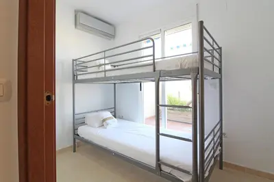 a bedroom with a bunk bed and a window at Global Vacacional, Impresionante ático para 8 personas en Canet d'en Berenguer in Canet de Berenguer