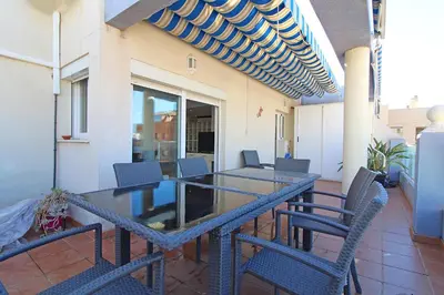 a patio with a table and chairs on a balcony at Global Vacacional, Impresionante ático para 8 personas en Canet d'en Berenguer in Canet de Berenguer
