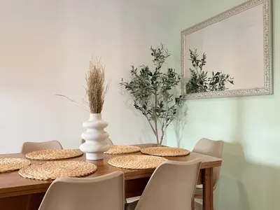a dining room table with a white vase and chairs at Apartamento Playa Valencia Beach in Valencia