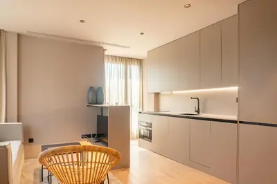 a kitchen with white cabinets and a table and chairs at Valencia Luxury - Sea Port I in Valencia