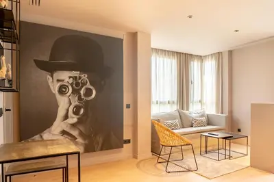 a living room with a painting of a person wearing a hat and a pair at Valencia Luxury - Sea Port I in Valencia