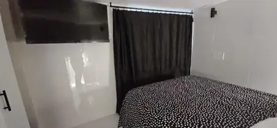 a bedroom with a bed and a black curtain at A6 ViviendaTuristicaValencia Ciencias in Valencia