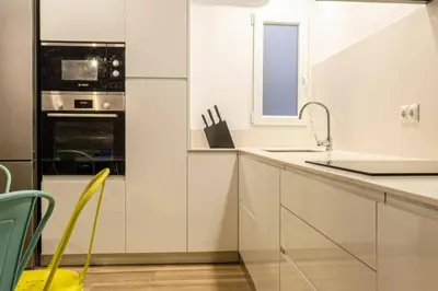 a kitchen with white cabinets and a sink and a window at Valencia Playa in Valencia