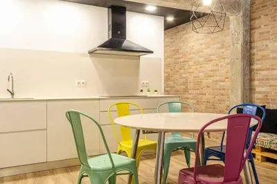a kitchen with a table and colorful chairs at Valencia Playa in Valencia
