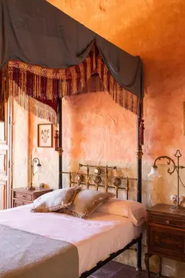 a bedroom with a canopy bed and a wooden table at Casa Museo RAKKANA - En el Centro de Requena in Requena