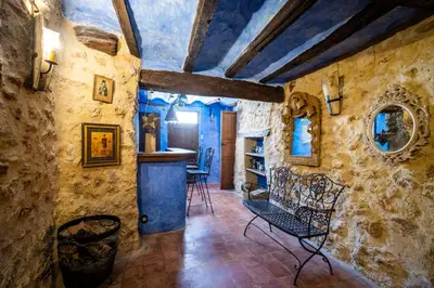 a room with stone walls and a table and chairs at Casa Museo RAKKANA - En el Centro de Requena in Requena