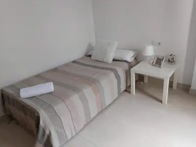 a bedroom with a bed and a side table at ÁTICO PATACONA BEACH PLAYA in Valencia