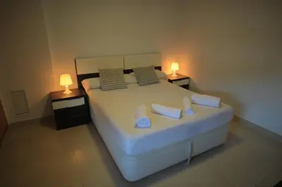 a bedroom with a large white bed with two lamps at ÁTICO PATACONA BEACH PLAYA in Valencia