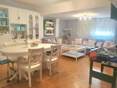 a kitchen and living room with a table and a couch at Amplio Apartamento Playa Puerto de Sagunto in Puerto de Sagunto