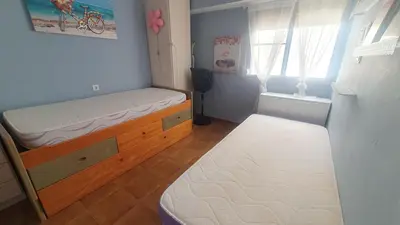 a small bedroom with a bed and a window at Amplio Apartamento Playa Puerto de Sagunto in Puerto de Sagunto