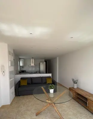 a living room with a couch and a glass table at UIM Mediterraneo Poeta 3 Wifi in Puerto de Sagunto
