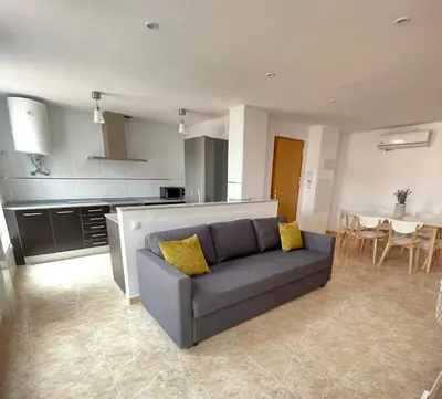 a living room with a couch and a kitchen at UIM Mediterraneo Poeta 3 Wifi in Puerto de Sagunto