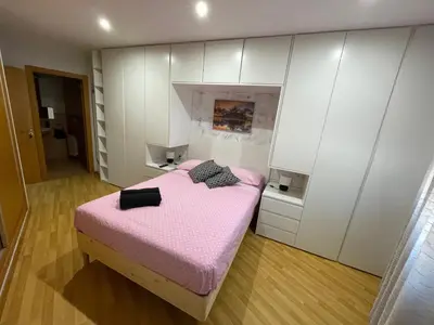 a bedroom with a pink bed and white cabinets at Apartamento San cayetano in Torrent