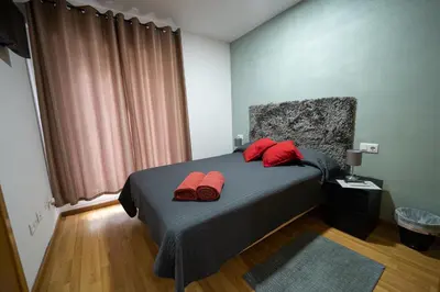 a bedroom with a bed with red pillows on it at Apartamento San cayetano in Torrent