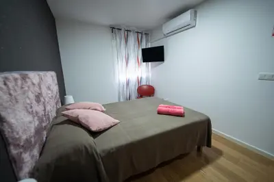 a bedroom with a bed with pink pillows on it at Apartamento San cayetano in Torrent