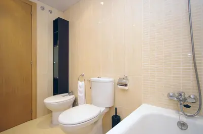 a bathroom with a toilet and a sink at Apartamentos Port in Valencia